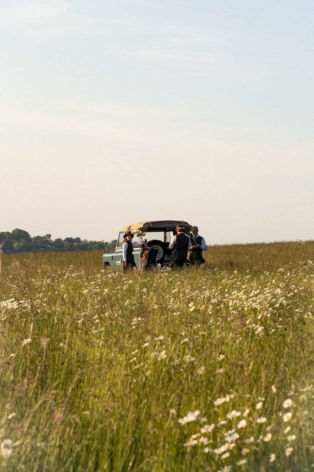 Wide field-of-wildflowers view of the Series Land Rover and the Dege & Skinner team on location